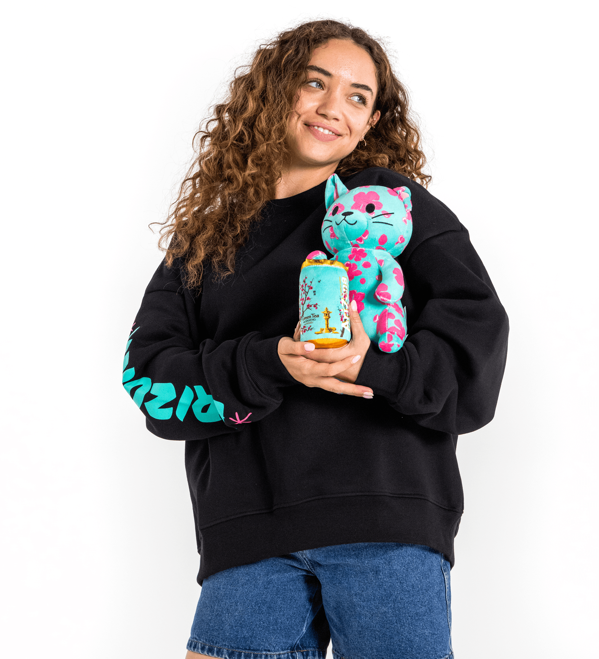 Person wearing a black AZ hoodie with colorful designs, holding a small figurine against a white background