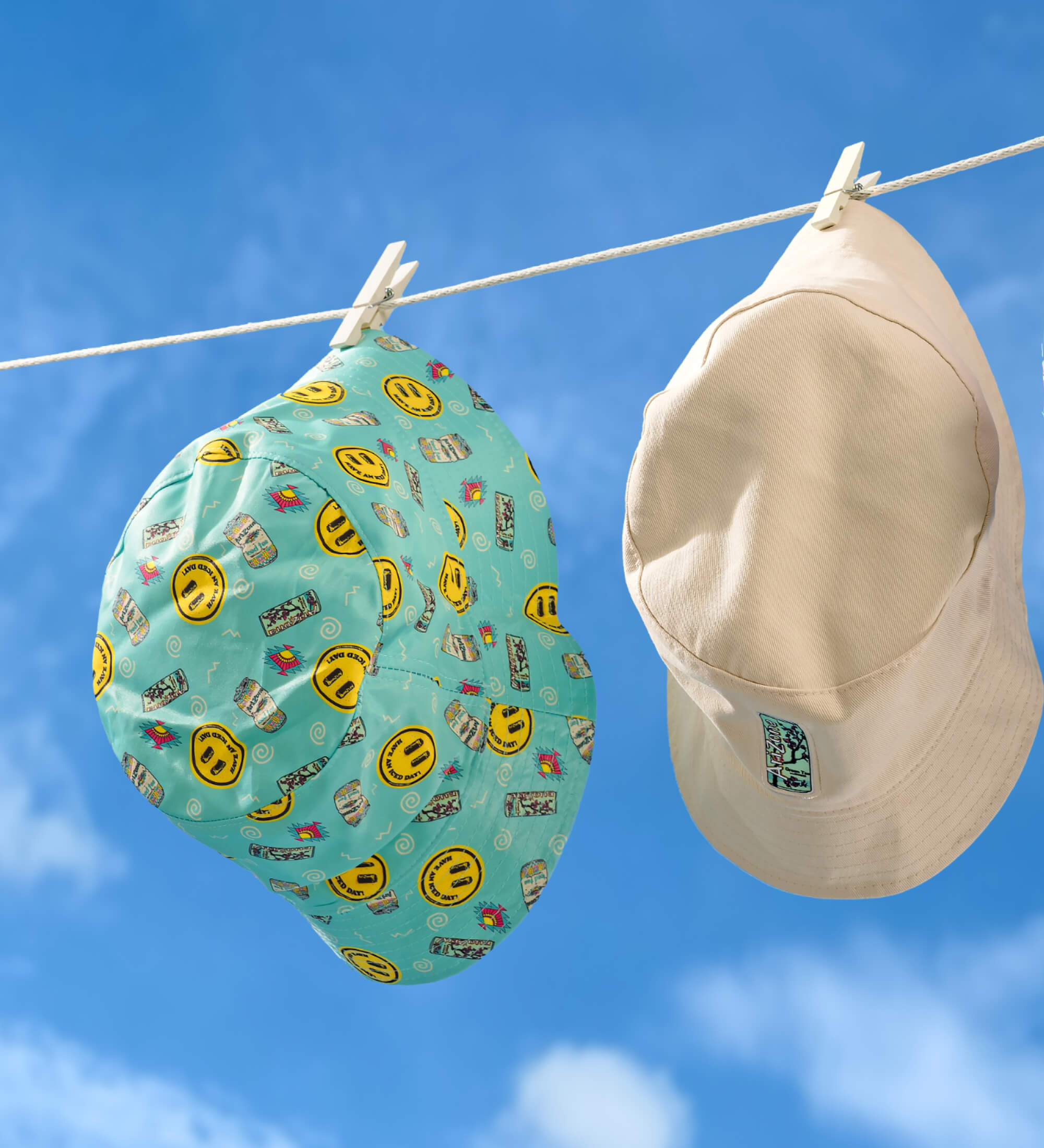 Two AZ hats hanging on a clothesline against a blue sky.