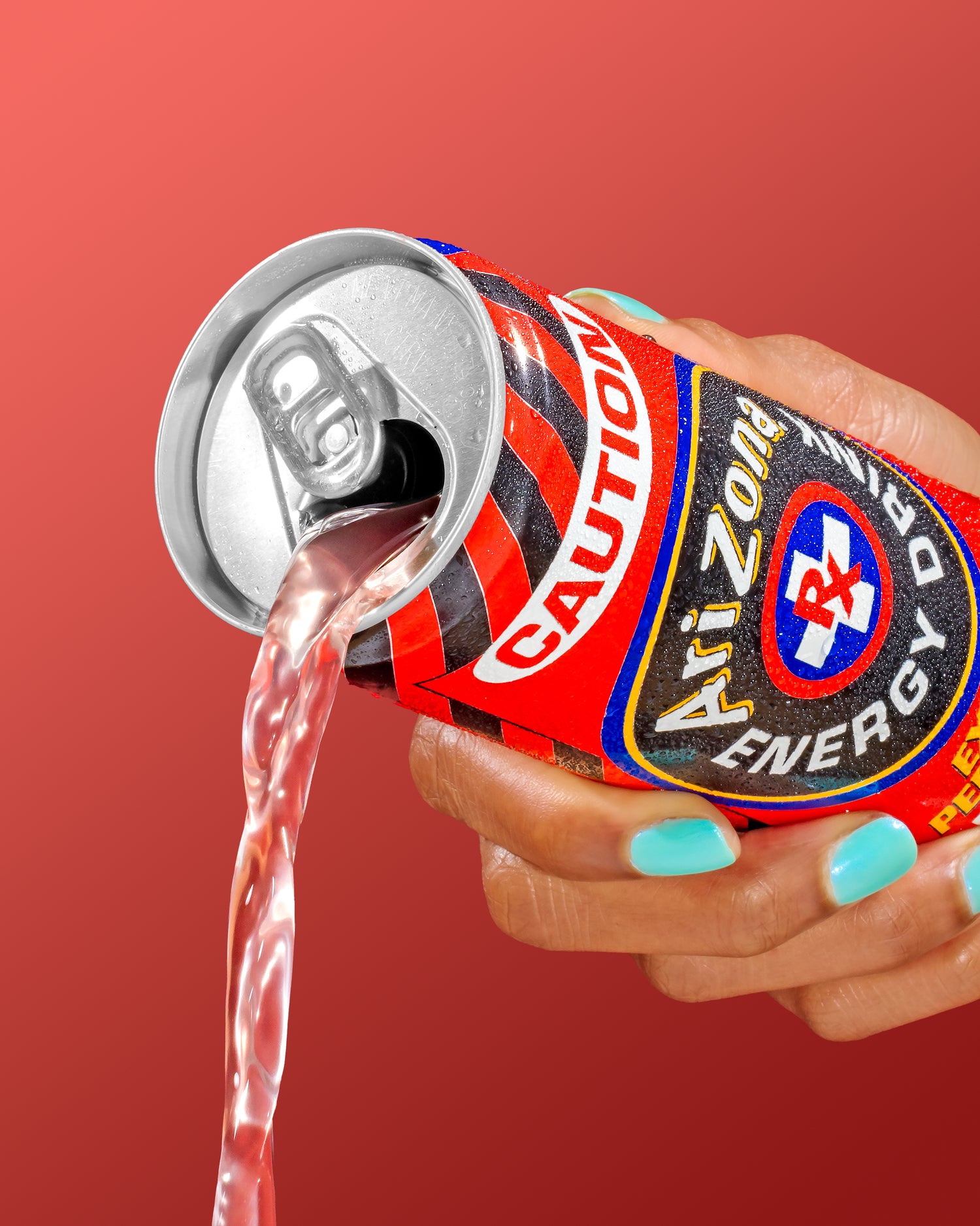 Hand holding an open can of Arizona Caution Energy Drink with red background