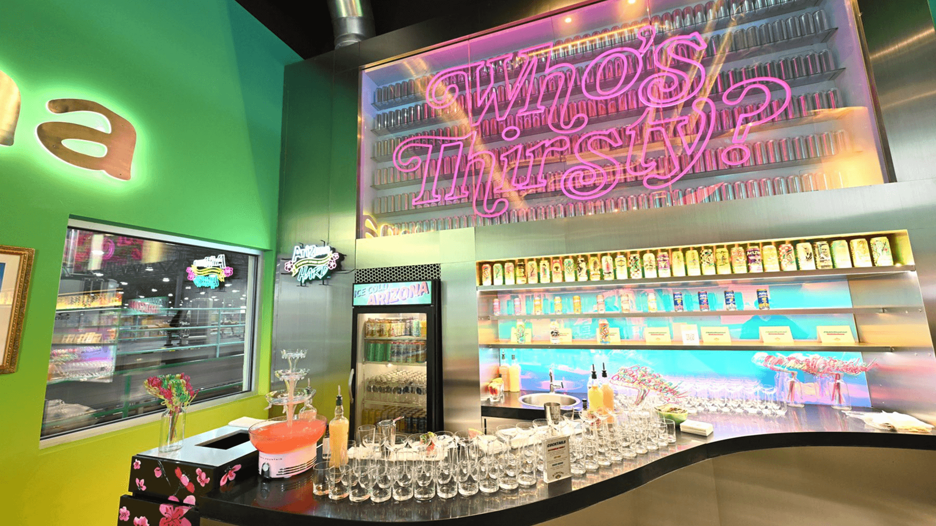 Neon sign with 'Who's Thirsty?' where people can try Arizona beverages at AriZonaLand