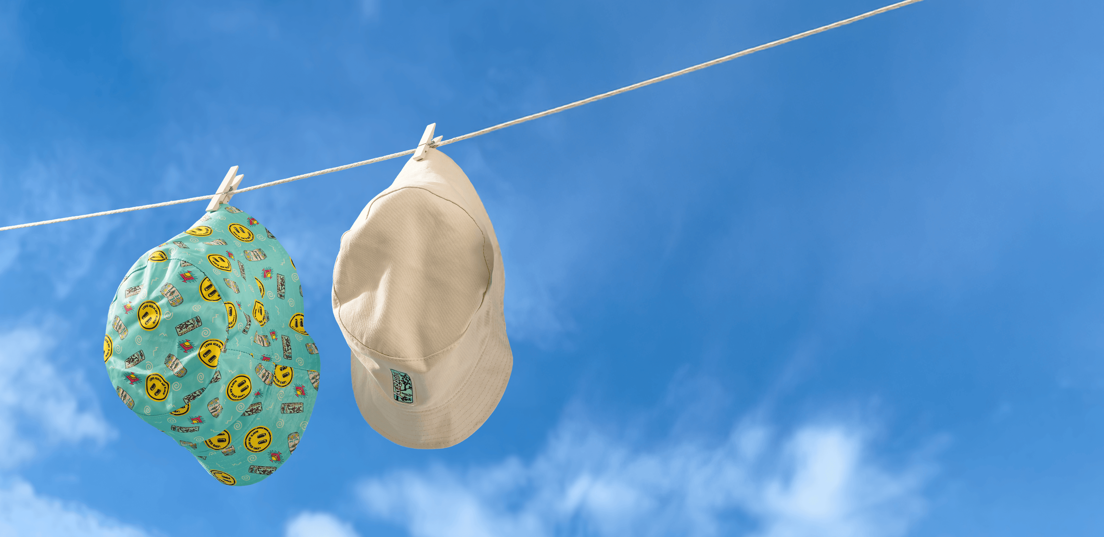 Two az hats hanging on a clothesline against a blue sky