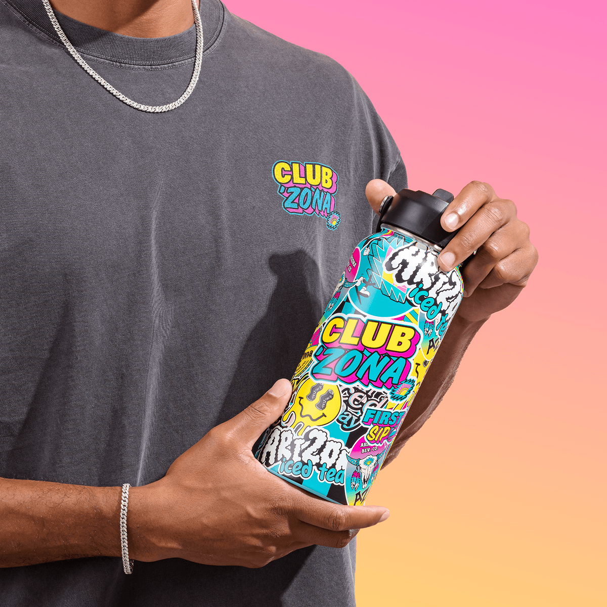 A person in a gray graphic t-shirt holds a colorful Club Zona insulated water bottle with a black lid against a pink and orange gradient background.