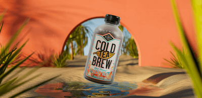 Peach Cold Tea Brew bottle with a desert background