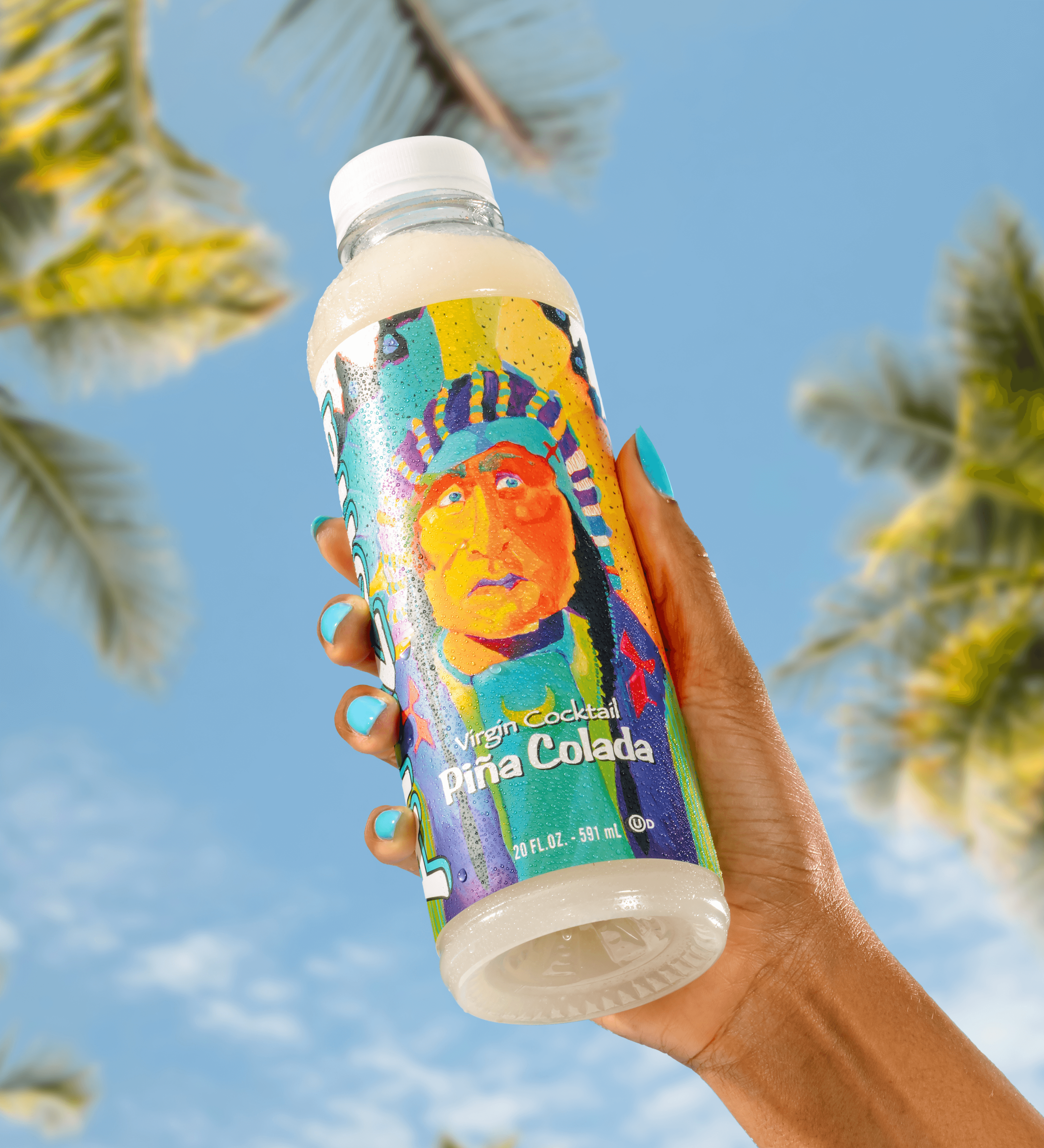 Colorful bottle of Virgin Cocktails Pina Colada held against a blue sky with palm trees.